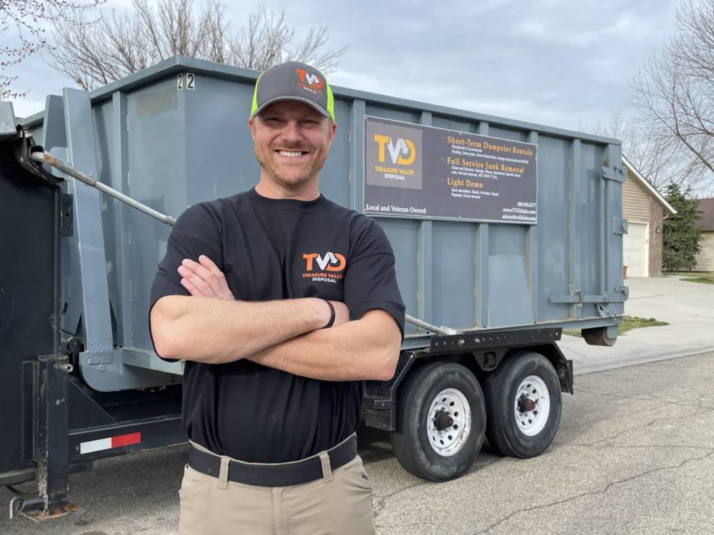 A Treasure Valley Disposal professional posing with a junk removal truck